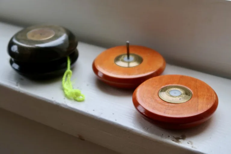 Two wooden Doble Ariel yo-yos, including one disassembled to show its axle and brass lapper discs